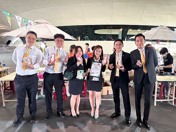 陳秋妮會長(圖右3)在市集上購買「伊甸幸福龍」娃娃贈送給同仁,邀請大家一起支持慢飛天使。圖/永慶房產集團提供