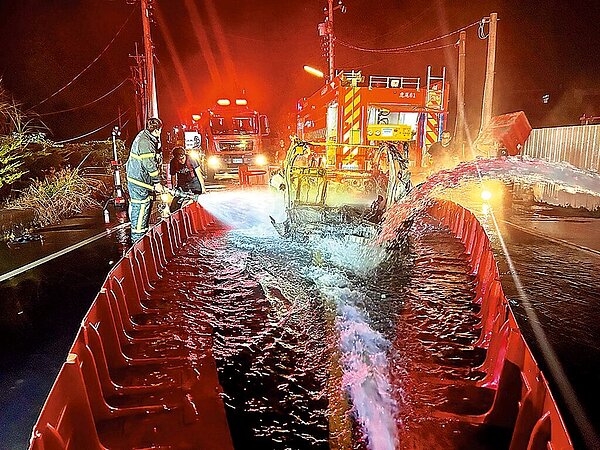 日前國道1號虎尾段發生特斯拉墜落平面道路後起火事故,雲林縣消防局緊急向縣府水利處商借擋水板圍成水池降溫才滅火。(民眾提供/周麗蘭雲林傳真)