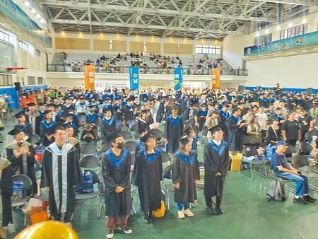 創校33年的環球科技大學15日舉行最後一次畢業典禮,畢業生們起立向師長敬禮致謝。(周麗蘭攝)