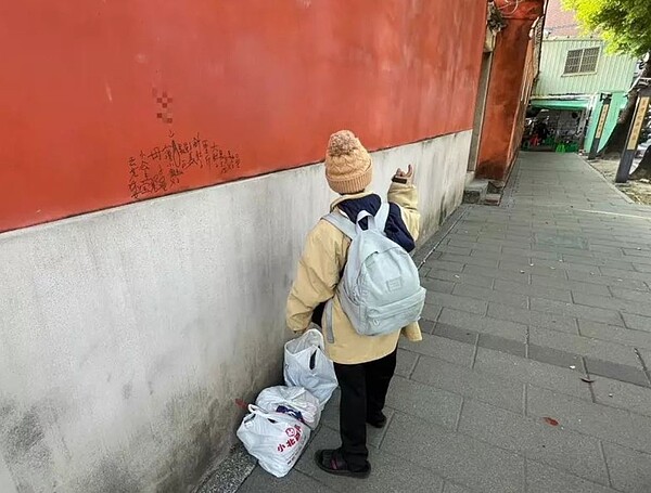 李姓女子1月20日下午1時45分許持黑色奇異筆,在台南國定古蹟祀典武廟後門牆壁處塗鴉,被依違反文化資訊保存法送辦。圖/讀者提供