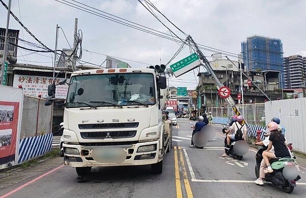 新北市新莊區新樹路、新莊路口,17日下午有1輛水泥預拌車違規行駛禁行路段,勾到道路上方電線,拉扯硬將交通號誌燈桿掰彎變形傾斜,幸未倒下壓到人車,除了罰款還要賠償。記者林昭彰/翻攝