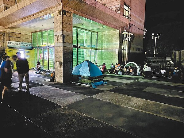 基市府推出基隆青年電動機車2.0方案,因申請量暴增,自14日改採限量申請,民眾開始漏夜排隊。圖為基隆市中山區公所外,民眾拿出帳篷來排隊情形。(議員施偉政辦公室提供/徐佑昇基隆傳真)