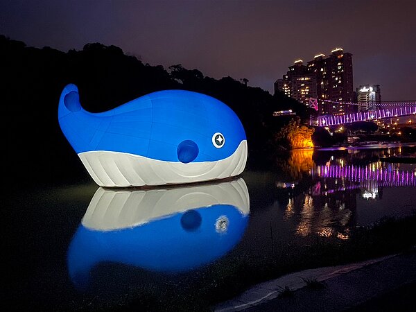 巨型超萌鯨魚晚間6時至10時點燈,在碧潭河岸持續閃耀,為今年夏天最鯨豔的打卡新地標。圖/新北市觀旅局提供