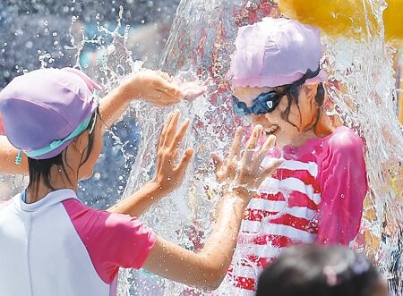 
各地持續悶熱，氣象署25日針對全台14縣市發布高溫資訊，小朋友們在自來水園區內開心地玩水消暑。（范揚光攝）
