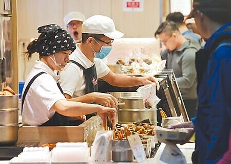 勞動部官員轉述報告內容,稱近5年基本工資調整有益於調高經常性薪資,對失業率及消費者物價指數影響則是微乎其微。圖為民眾購買食品。(本報資料照片)