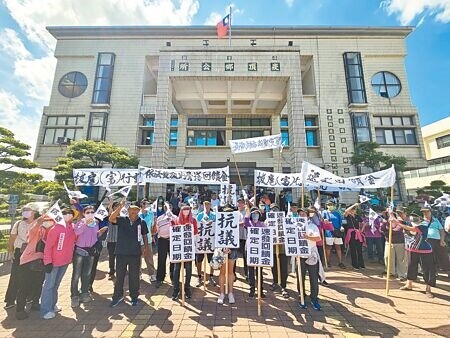 
崁頂生命紀念館去年9月啟用，原本承諾的10％回饋金至今未發放，居民到鄉公所前拉白布條抗議。（羅琦文攝）
