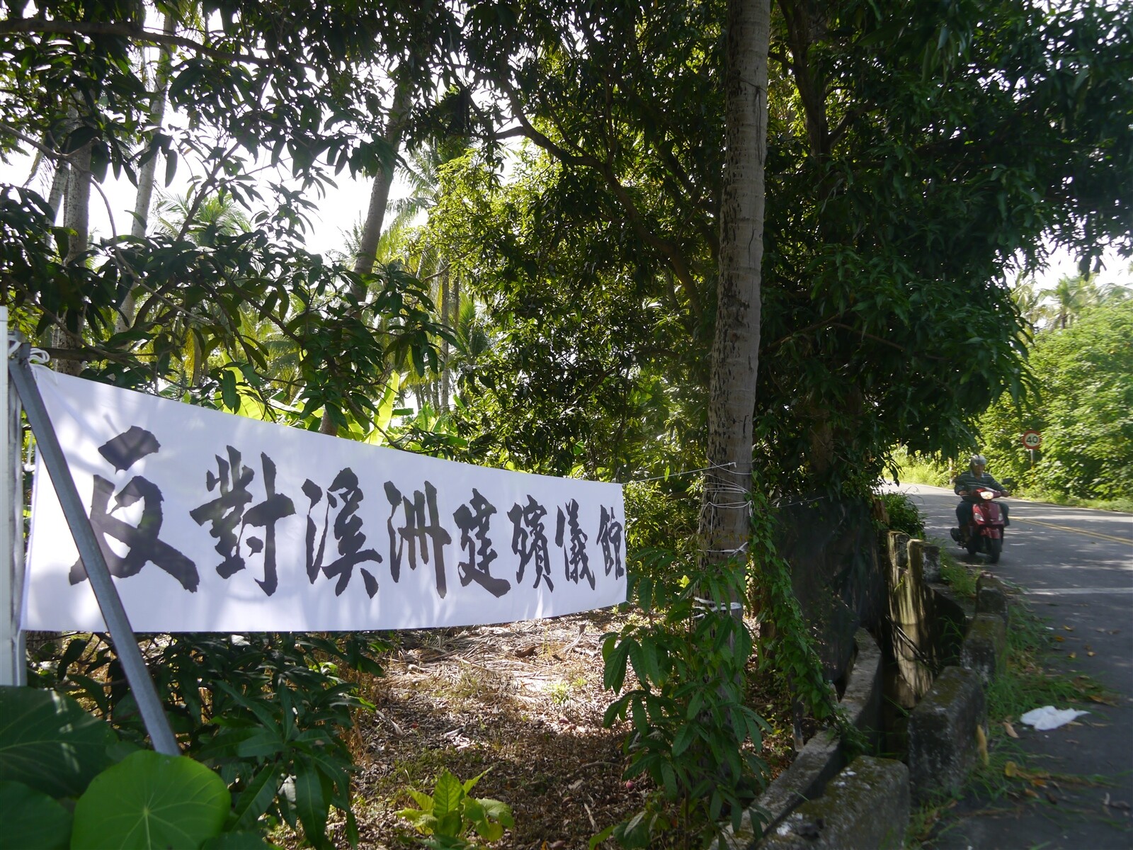 高市殯葬處7月5日上午10點召開旗山殯儀館公聽會，溪洲地區路口高掛抗議布條，反對殯儀館進駐鄰近聚落的公墓用地。記者徐白櫻／攝影 