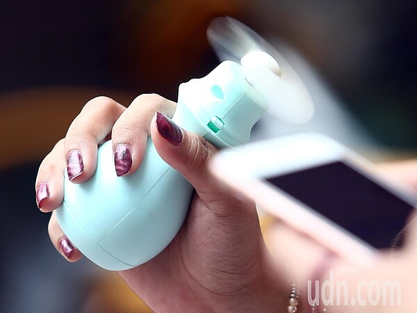 近來台灣天氣熱炸,不少人外出會攜帶手持隨身風扇降溫。聯合報系資料照/記者杜建重攝影