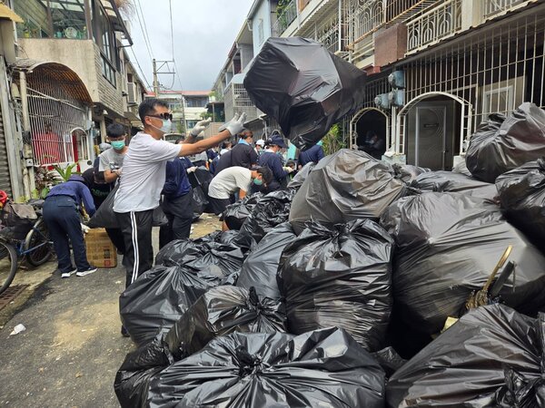 台南市北區區公所邀集近百位志工，協助清理轄內一處「垃圾屋」民宅，前後共清出20噸雜物，還給當地整潔的環境，也解決附近居民長年來的困擾。圖／北區區公所提供