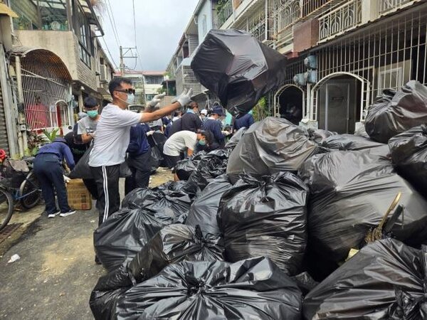 近百名志工與公所人員協力清出20噸雜物，堆積如山的垃圾場面驚人。圖／台南市北區區公所提供