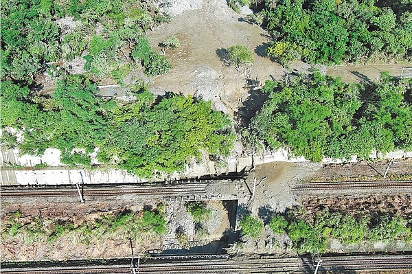 台9線蘇花公路崇德至和仁路段1日晚間因山區強降雨有多處坍方，土石溢流路面及鐵軌，造成鐵公路交通中斷，經工務人員投入搶災，台鐵列車2日恢復通行，但公路因邊坡含水量過高又遇大雨，增添搶修難度，預計3日下午2時才能搶通。（公路局提供／羅亦晽花蓮傳真）