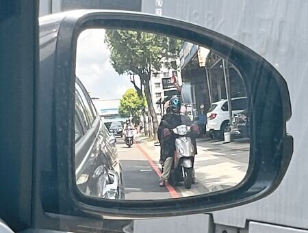 機車騎士為躲避酷暑豔陽,在停等紅綠燈時,常騎至邊線外等候。(邱立雅攝)