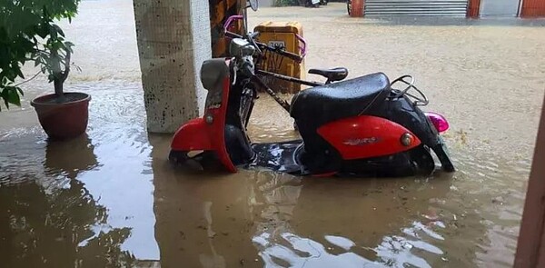 雨炸台北市，10日下午除大安信義時雨量驚人，台北市內港也有多處積淹水，議員李明賢也在臉書貼出南港成福路附近店家淹水，不僅淹沒路面，淹水高度也超越半個摩托車高度，李明賢說，「簡直就像颱風一樣」。