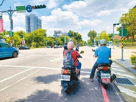 
為躲避豔陽，機車騎士停等紅綠燈時都會盡量找樹蔭躲。（陳慰慈攝）
