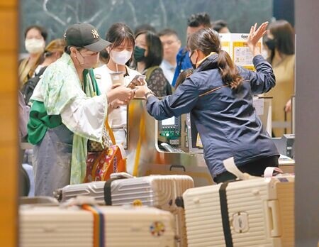 
受全球微軟系統19日大當機影響，桃園機場有6家航空公司改採人工畫位，2家航空公司從外站暫停起飛。第一航廈受影響的航空公司地勤人員以人工劃位方式，為旅客辦理報到手續。（范揚光攝）
