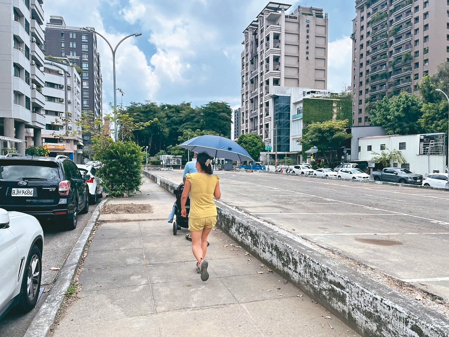 台中市西區土庫停車場人行道28棵掌葉蘋婆，近日因人行道改善工程全數砍除，光禿禿一片，路人汗流浹背直喊好熱。記者洪敬浤／攝影 