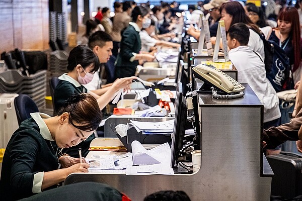 桃園機場因部分航空公司離境報到使用微軟雲端系統Navitaire，無法電腦作業，改採人工劃位。記者季相儒／攝影