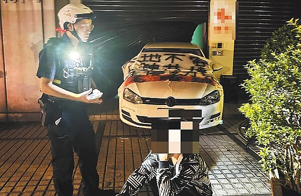 台北市某托嬰中心21日凌晨被馬姓男子倒車衝撞鐵門,並在車上貼布條洩憤,警方趕往將他逮捕。(警方提供/胡欣男台北傳真)