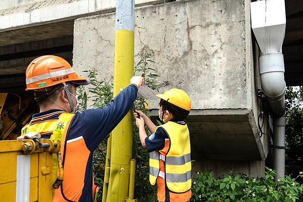 小朋友體驗撕除違規小廣告。〈環保局提供〉