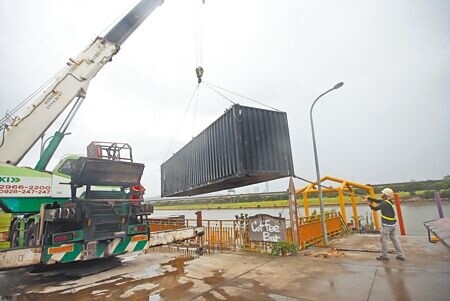 
中颱凱米來勢洶洶，北市美堤河濱公園23日業者請來吊車將貨櫃屋吊起安置，以防意外發生。（趙雙傑攝）
