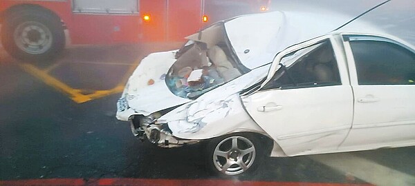 凱米颱風來襲,花蓮市中興路24日有建物女兒牆被強風吹掀的鐵皮推倒掉落,把停在路旁的車子後車廂壓扁,造成後座的母子受到重創,45歲高姓婦人傷重死亡,7歲兒子則陷入昏迷在加護病房搶救。圖/花蓮縣消防局提供、羅亦晽花蓮傳真