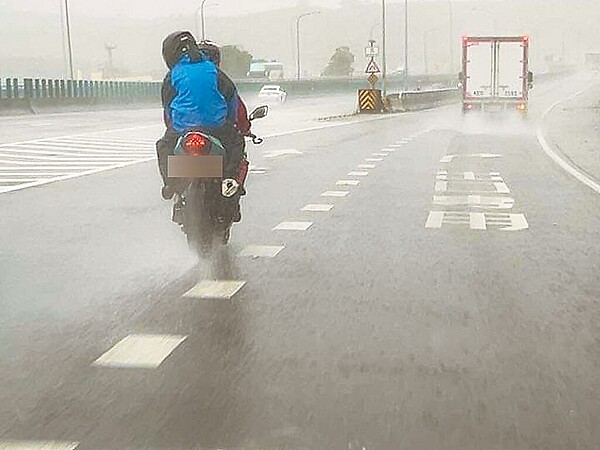 一部黃牌重機騎上國道1號中山高速公路彰化路段，並在強風豪雨中一路向北行駛。圖／民眾提供