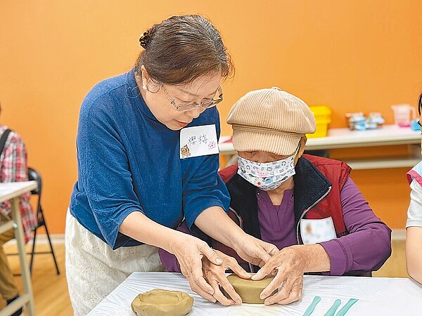 銀髮生活達人傅櫻梅老師參與社福活動，與失智家庭分享捏陶樂趣。圖／台中市府提供