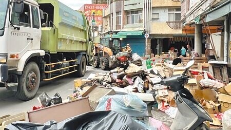 
台南市鹽水區淹水受災戶27日趁放晴，趕緊清理家園，清潔隊出動垃圾車、山貓等協助清運。（張毓翎攝）
