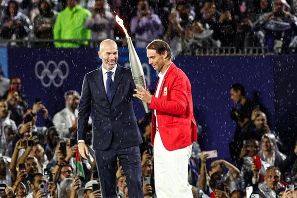 法國傳奇足球明星席丹（Zinedine Zidane）（左）擔任2024巴黎奧運聖火傳遞火炬手之一，將火炬交棒給驚喜亮相的西班牙網球好手納達爾（Rafael Nadal）（右）。記者季相儒／攝影