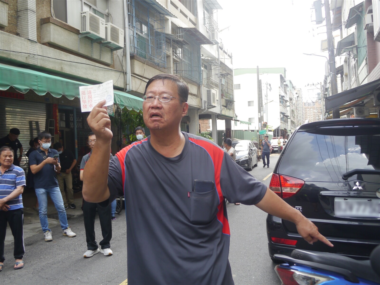 鳳山區文西街居民拿著交通罰單氣憤陳情說，車子停在自家騎樓被警方開單，非常不合理。記者徐白櫻／攝影 