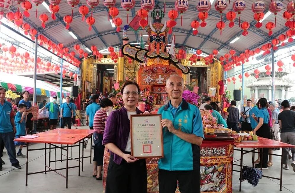 高雄市文化局副局長簡美玲(左)代表高雄市政府,頒授證書給小港龍湖廟董事長李文洲(右)。圖/高史博提供