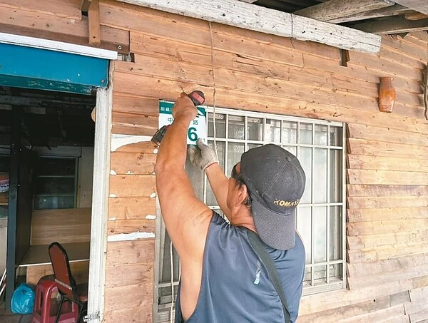 施工人員拔下高雄拉瓦克部落的最後一個門牌,近70年歷史畫下句點。圖/高雄市政府提供