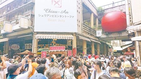 「紅球計畫」流動街頭藝術30日移置台南市永樂市場2樓空橋，國華街被人潮擠得水泄不通。（程炳璋攝）