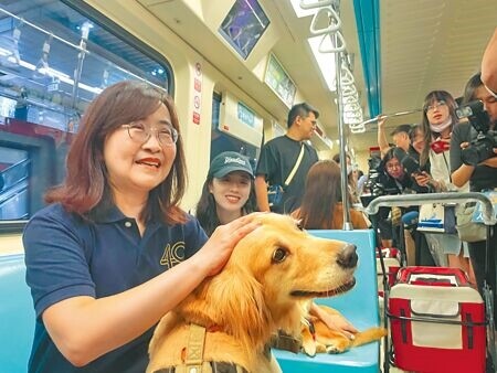 
台北市副市長林奕華（左）3月31日搭乘台北捷運推出的「寵物友善列車」，上車後被狗狗熱烈歡迎，到站時她直呼「捨不得下車」。（劉彥宜攝）
