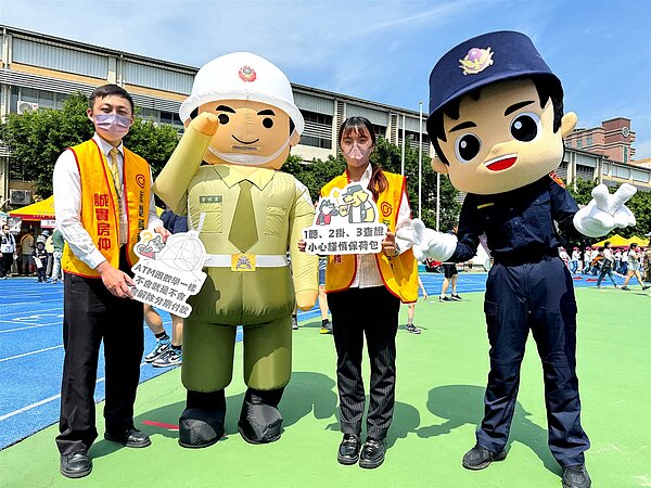 永慶房屋擔任童玩鄰舍節活動志工,與警察局和憲兵隊人偶一起拿著手舉牌,宣導反詐資訊。