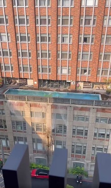 桃園古華飯店頂樓泳池傾洩流下大樓,下方停放的汽機車直接遭殃。圖/翻攝自爆廢1公社