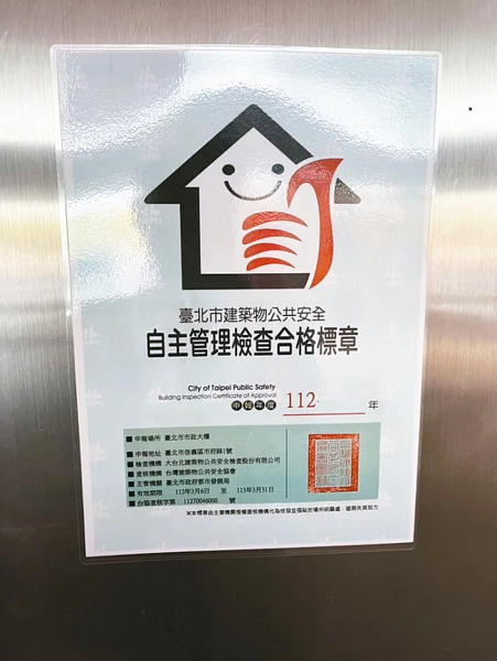 台北市府大樓在1樓張貼「公共安全自主檢查合格標章」,但議員發現竟於3月底已經逾期。圖/議員鍾佩玲提供
