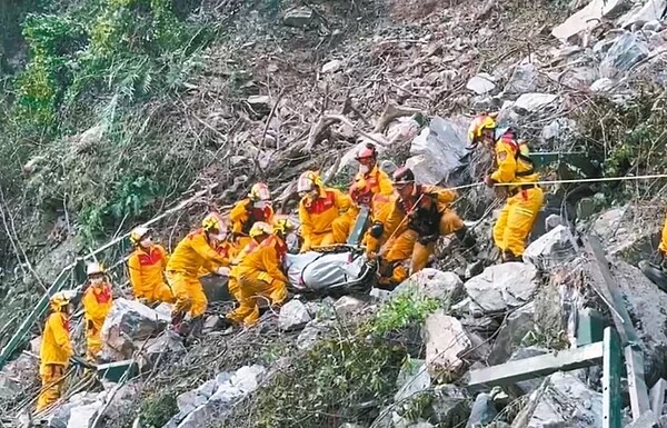 屏東縣特搜人員昨挺進小錐麓步道，在陡峭土堆中將圍欄等障礙物清除，搬出連男遺體再送上救護車。圖／屏東縣消防局提供

