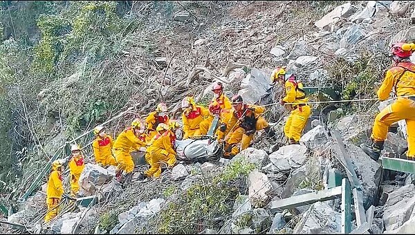花蓮強震再增1死,特搜隊4日下午在太魯閣國家公園小錐麓步道發現一名男子遺體,眾人以接力方式將遺體搬運下山。圖/屏東縣消防局提供