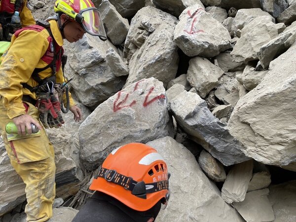 救難人員在太魯閣砂卡礑步道發現2具遺體被壓在巨石下，將破壞巨石將人拉出。圖／救難隊提供