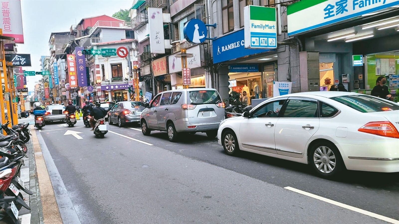 警方假日管制義二路內側讓信二路停車場車輛排隊，其他車被迫開在外側直行車道，但右轉就違規。記者游明煌／攝影 