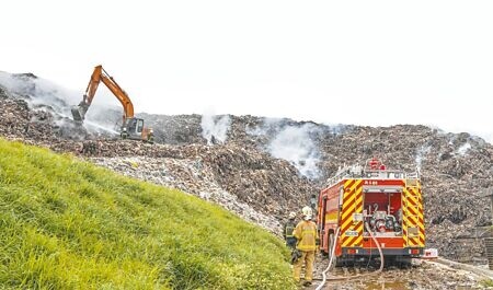 
新竹縣新豐垃圾掩埋場發生沼氣引發的自燃火警，6日火勢撲滅後仍處於悶燒狀態，現場調派怪手將堆置垃圾挖開，希望能降溫，避免火勢復燃。（羅浚濱攝）
