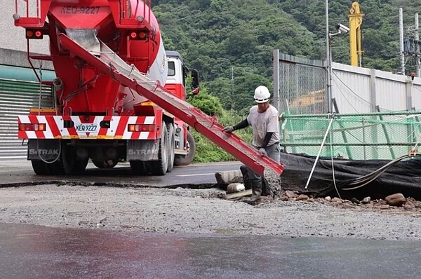 蘇澳鎮某飯店施工大量湧水、淘空地底泥沙，緊鄰工地道路塌陷2米深、20平方公尺「天坑」，承包商自己回填，現場未豎立警示標語。圖／鎮公所提供
