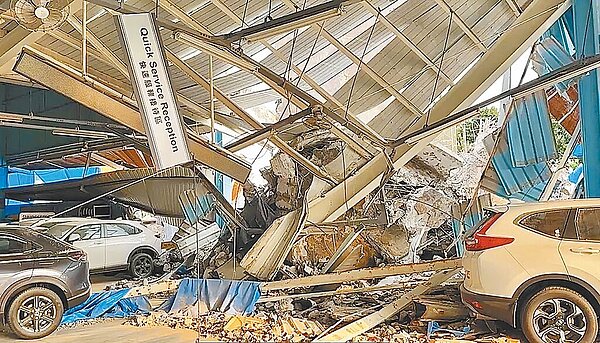 草屯鎮寫著「草農牌飼料」水泥儲存塔倒塌,壓毀修配廠及8輛汽機車。(民眾提供/楊靜茹南投傳真)