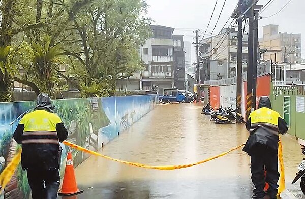 18日上午新北市汐止區崇德國小前中華街、茄苳路口積水達30公分，警方到場拉起封鎖線，管制人車通行。圖／汐止警分局提供