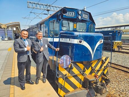 台鐵公司副總經理劉雙火（左）及日本JR四國專務取締役鐵道事業本部長長戶正二（右）在藍皮解憂號前合影，台、日兩列藍色觀光小火車締結姊妹車輛。（羅琦文攝）