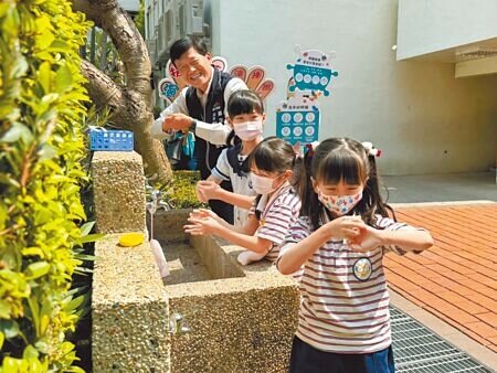 腸病毒提早進入流行期,台中市衛生局攜手麥當勞叔叔之家慈善基金會,22日上午於中教大附設實驗小學宣導正確洗手觀念;衛生局長曾梓展(後)與小朋友示範正確洗手步驟。(潘虹恩攝)