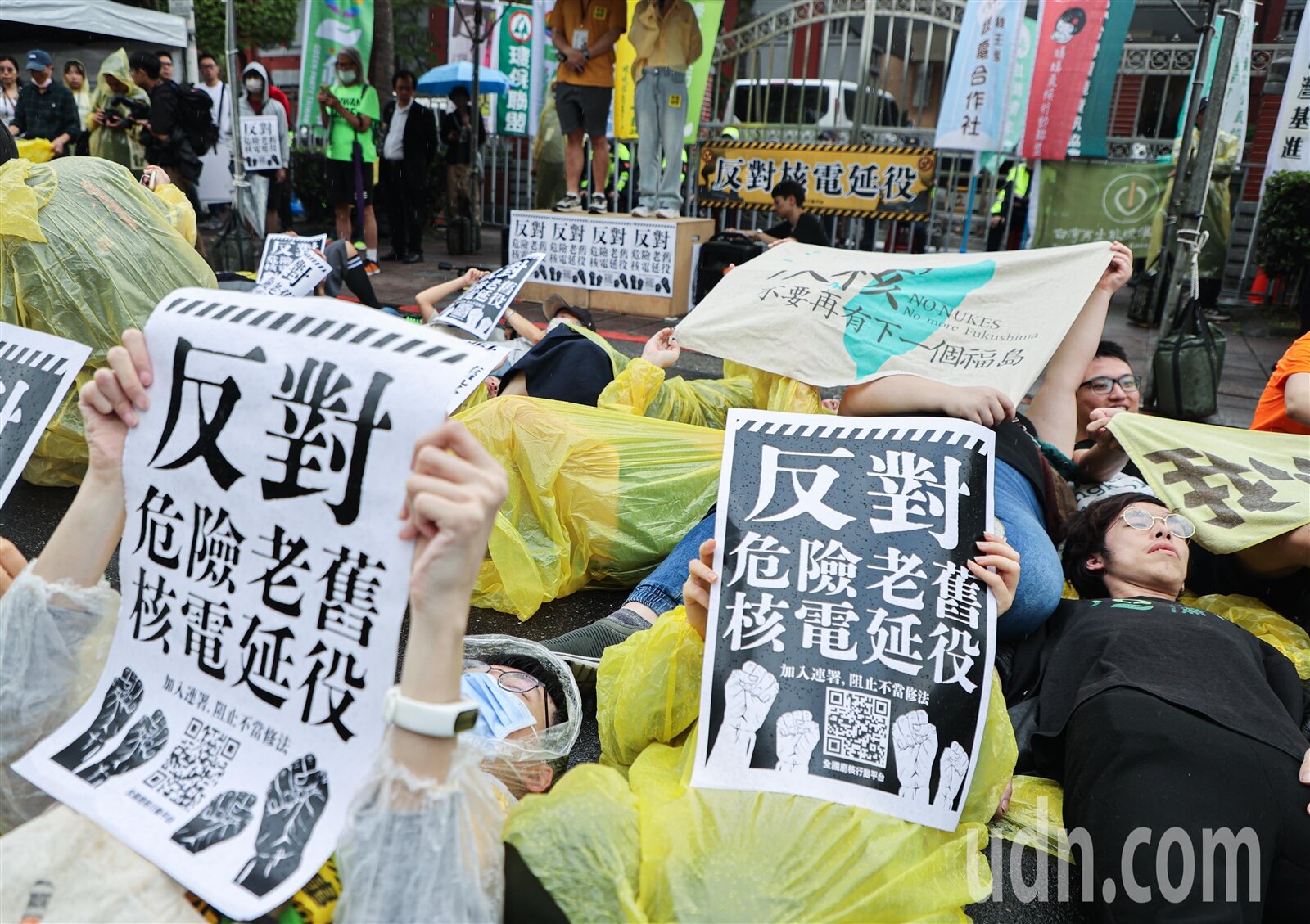 4月27日為忠孝西路反核抗爭10週年，下午數個反核及公民團體於立法院門口，重演10年前模擬核災警報時，躺下避難情況，並高舉反對危險老舊核電延役標語。記者曾原信／攝影 