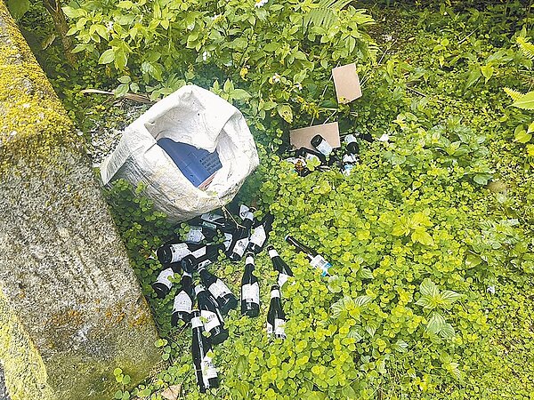 新北市新店區安泰路草叢發現大量被人丟棄的營建廢棄物、廢棄娃娃機台及過期啤酒瓶。(新北市環保局提供/高鈞麟新北傳真)