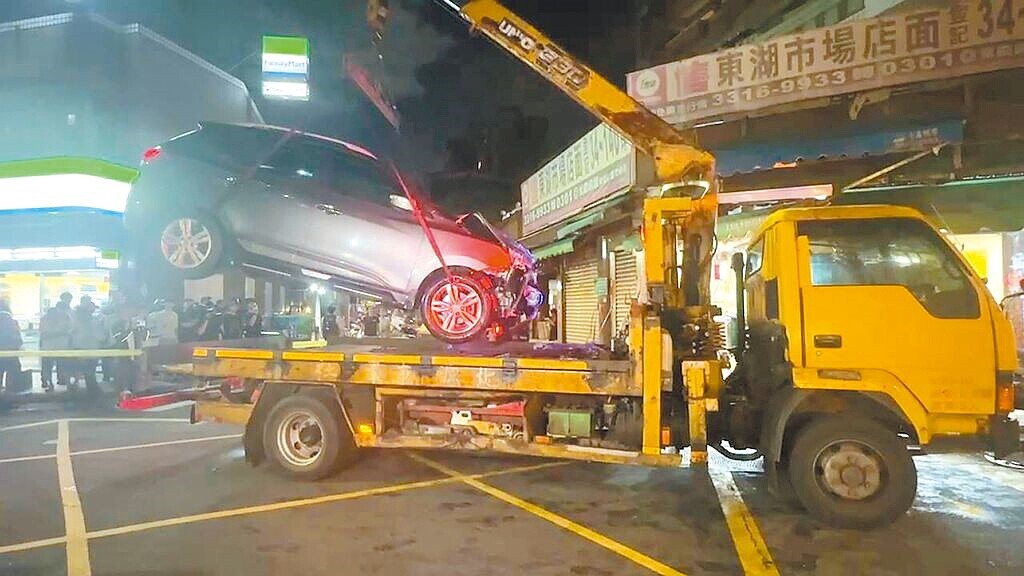 15歲曾姓少年開車撞進東湖市場附近的小吃店，警方將肇事休旅車拖離。圖／民眾提供